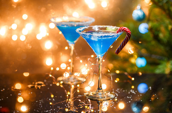 Christmas photo of two wine glasses with blue cocktail and garland