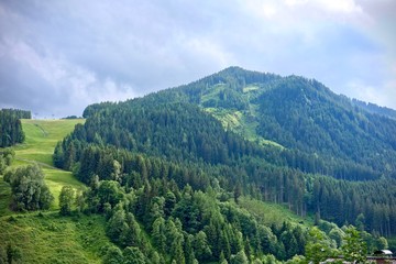 lush green alpine peak under a blue cloudy sky in Saalbach, Austria