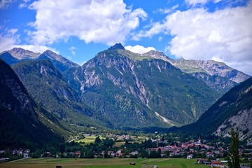 Fototapeta na wymiar alpine peaks and valley under a blue cloudy sky in Nassereith, Tirol