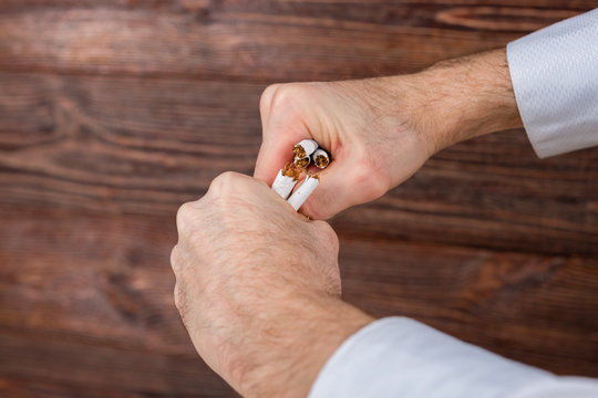 Man breaks cigarettes in his hands. Quit smoking. Concept.