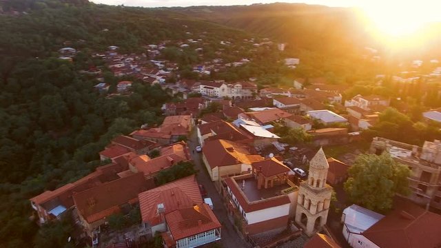 Drone flying over the green hills and beautiful buildings in Sighnaghi at sunset