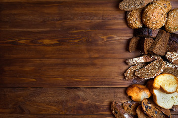 Assortment of baked bread on wooden table background
