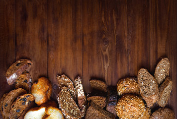 Assortment of baked bread on wooden table background