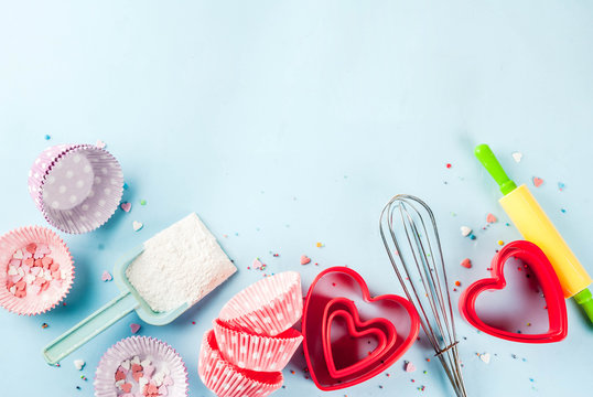 Sweet baking concept for Valentine's day,  cooking background with baking - with a rolling pin, whisk for whipping, cookie cutters, sugar sprinkling, flour. Light blue background, top view copy space
