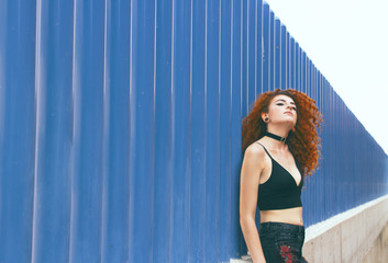 Modelo alternativa pelirroja posando en un entorno urbano 