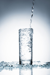 cold water pouring into glass on white