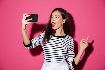 Naklejka premium Portrait of a pretty girl taking a selfie