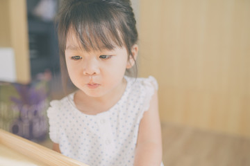 Fototapeta premium child girl happy look smart phone. asian child.Child development.Little asian girl look smart phone in living room