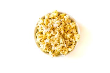 pile of caramel popcorn in ceramic bowl on white background