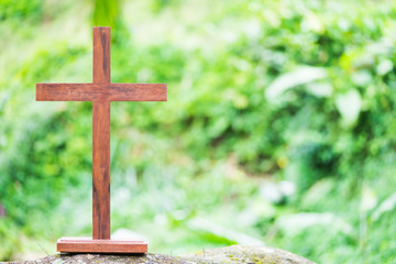 A wooden cross on a green background