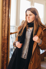 Young fashion girl walk on stairs and look around with different face expression. Warm winter clothing with sunset background