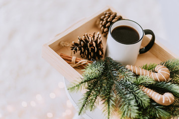 Obraz na płótnie Canvas coffee in a white cup and cones of Christmas tree
