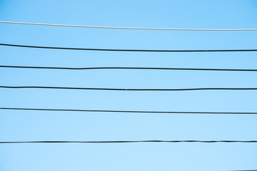 silhouette electric power line with cable wire against blue sky for background