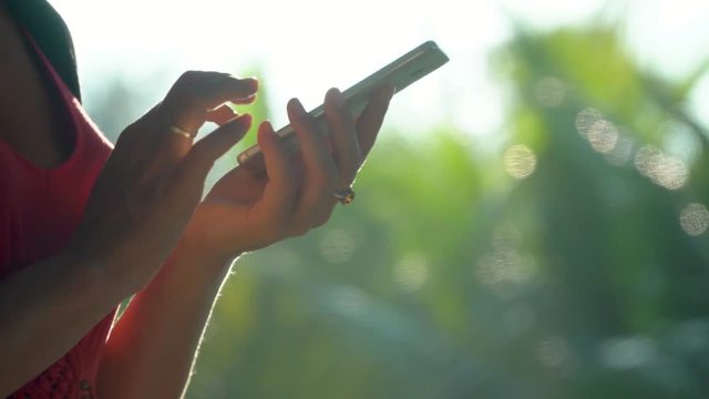 The woman will erase the card at herself in the smartphone. A silhouette of hands with phone. Hands close up. Vietnam..
