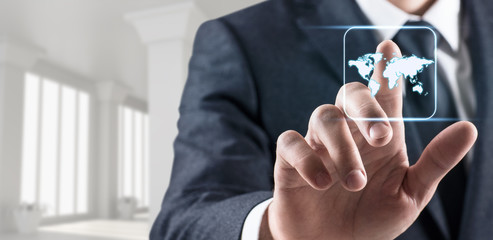 Businessman's hand touches glowing world map.