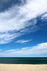 Meer, Sandstrand und Himmel mit Wolken