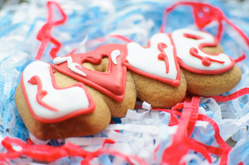 Letter cookies for Valentine's day or for a wedding day on the blue and white paper filler background.