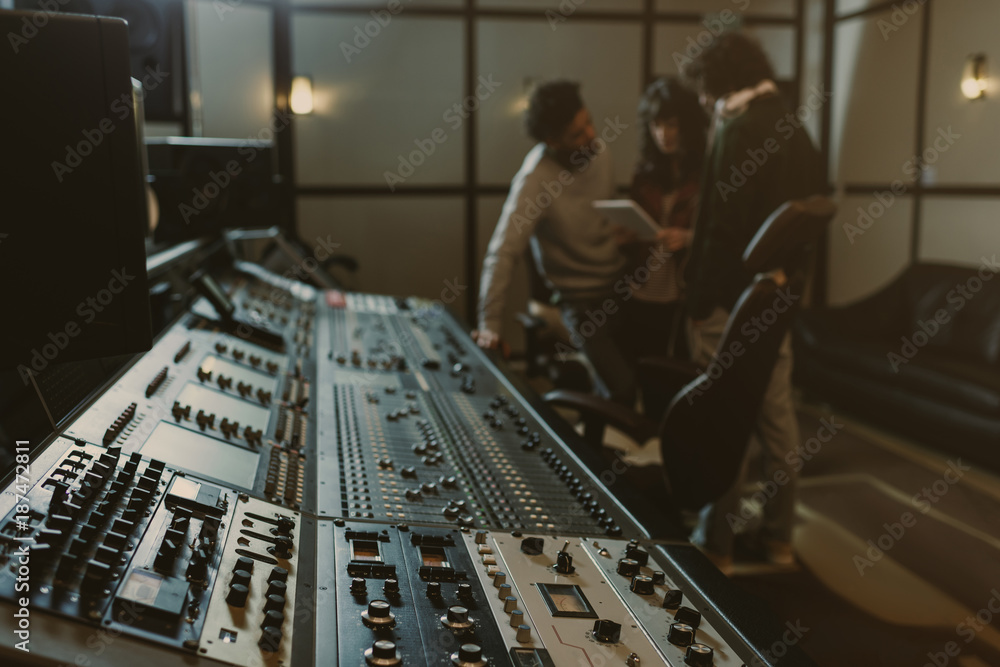 Poster blurred group of musicians spending time at recording studio with graphic equalizer