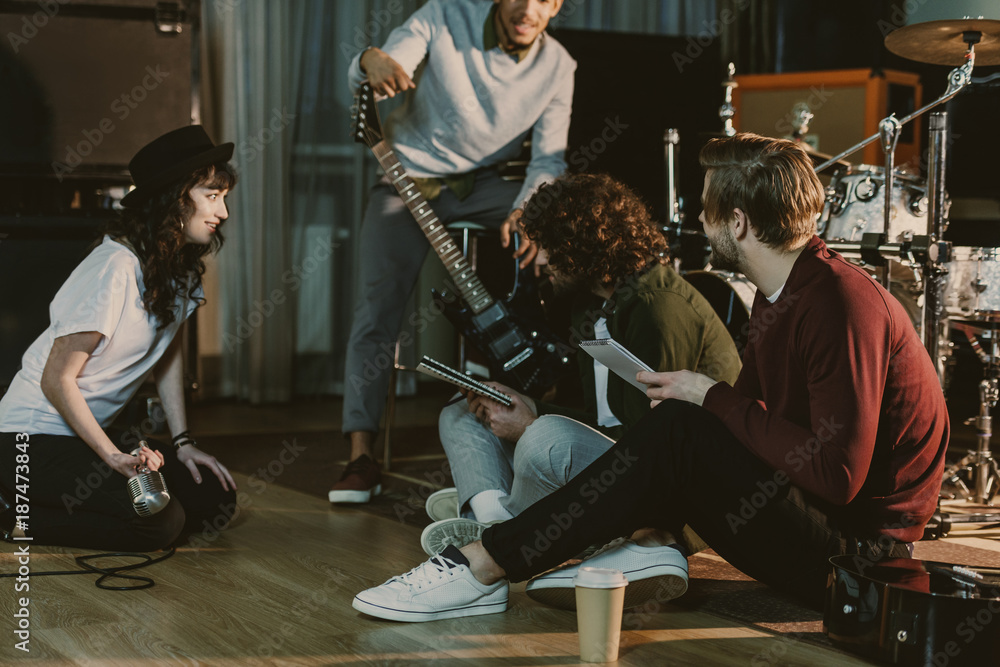 Wall mural music band sitting on floor and creating text for song together