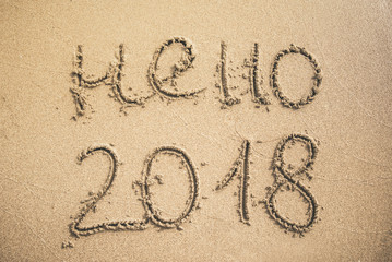 Hello 2018 text written on the sand