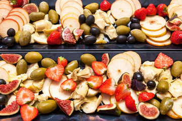 Sliced fruit figs strawberries pears olives strawberries.