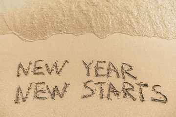 New Year New Starts text written on the sand