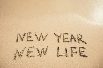 New Year New Life text written on the sand