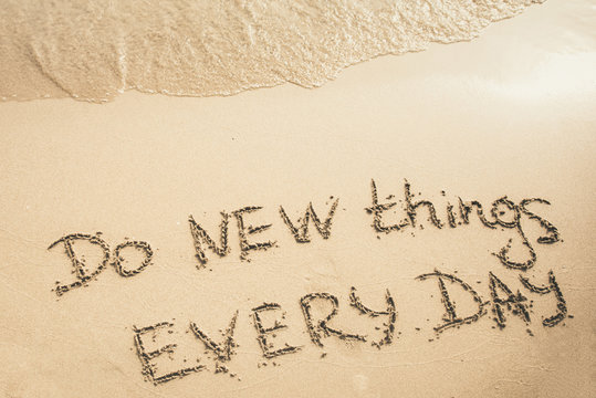 Do New Things Every Day text written on the sand