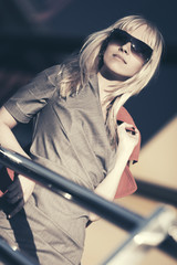 Young fashion business woman in sunglasses at office building