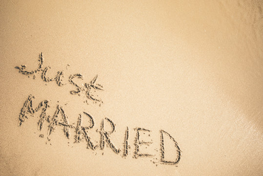 Just Married text written on the sand