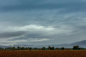 Plowed field near a kibbutz in the north of Israel, a machine for watering 