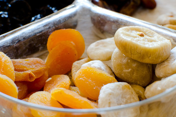 dried figs and apricots in glass transparent bowl close up