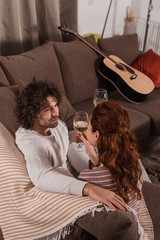 Naklejka premium high angle view of couple holding glasses with champagne and looking at each other