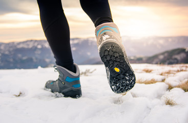 Person hiking on the mountaintop covered with snow