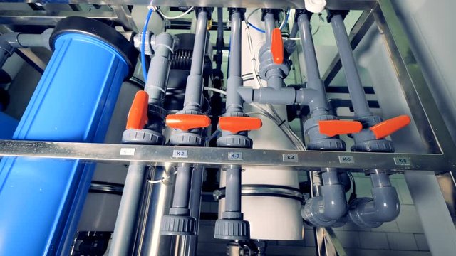 A zooming out shot on water purification system plumbing. 