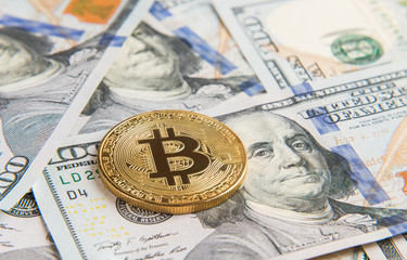 Golden bitcoin on heap of dollars