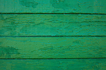 Wooden boards painted in green. Old green background. Painted wood surface. The surface of the wooden green train car. The parallel lines of the boards