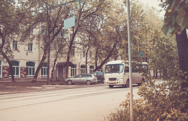 Urban landscape with old bus on road. Retro toned.