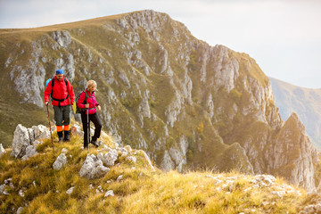 adventure, travel, tourism, hike and people concept - smiling couple walking with backpacks outdoors