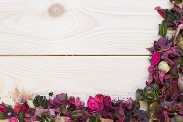 Wooden background with a corner of petals and leaves