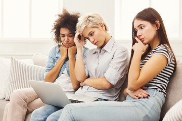 Fototapeta na wymiar Three sad women using laptop at home