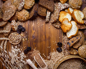 Assortment of baked bread on wooden table background