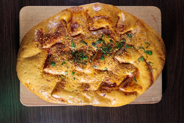 Pita bread on cutting board on wooden table