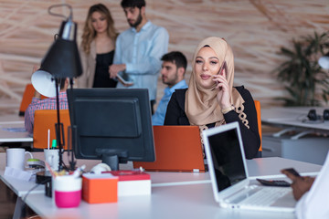Beautiful phone operator Arab woman working in modern startup office