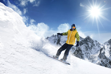 A snowboarder on the top of the mountain. He is sliding down a mountain slope, ski season and great...