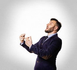 Emotional dialogue of a man in a suit. Portrait of a bearded man on a light background.