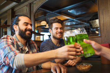 male friends drinking green beer at bar or pub