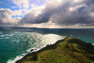 Dramatic light landscape of Pacific Ocean wild coast with lighthouse on the top of the rock. Northernmost point Cape Reinga, North Island of New Zealand