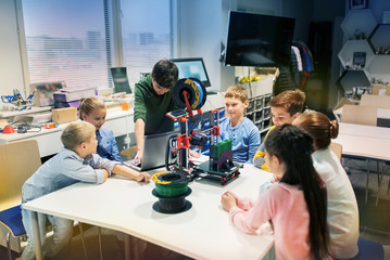 happy children with 3d printer at robotics school