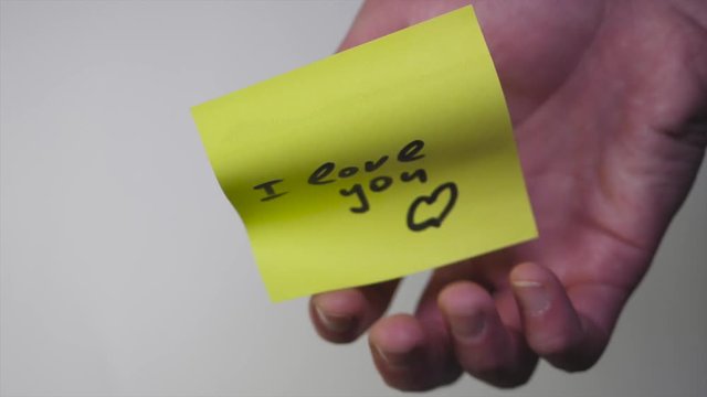 Drawing "i love you" on yellow paper. Inscription on the sticker I love you on white background